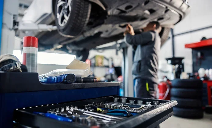 Mécanicien entretenant un véhicule en atelier au Garage du Centre à Dun-Le-Palestel (23)